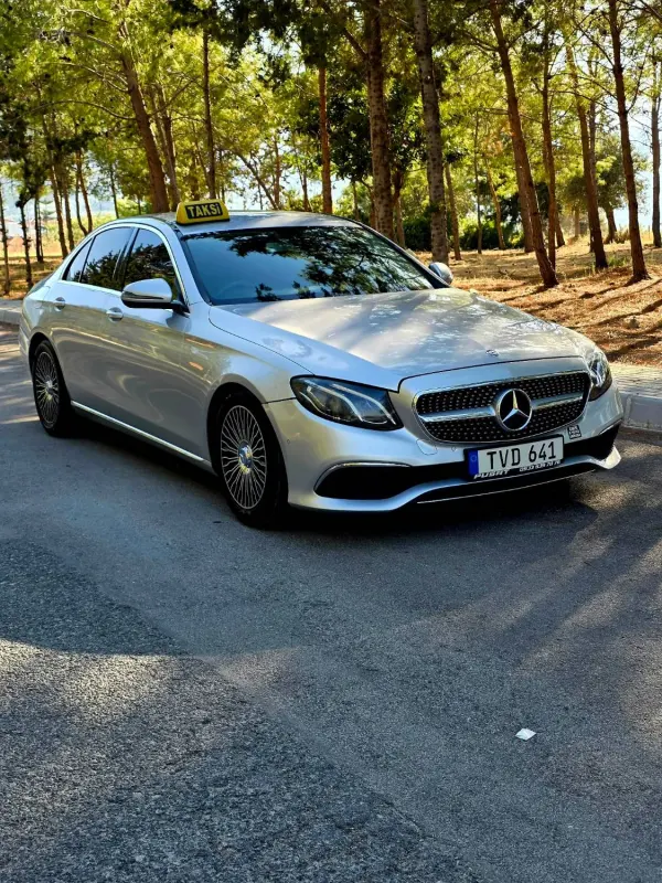 Çam ağaçları arasında gümüş Mercedes E-Class taksi, Kıbrıs